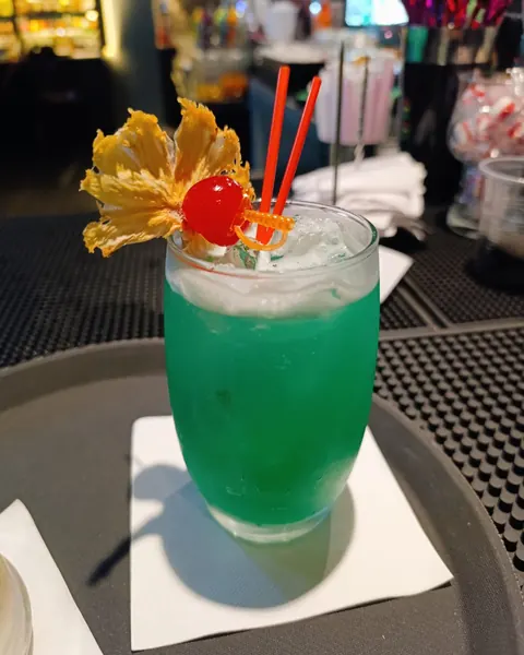 Mermaid Rum Punch cocktail, blue-green with a fruit garnish